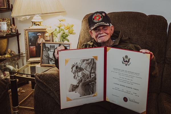 Retired U.S. Marine Corps Staff Sgt. Ismael Gonzalez-Ramos, a former infantry unit leader and decorated combat veteran, poses for a photo with his certificate of retirement at his home in Jacksonville, North Carolina, Nov. 20, 2023. 92-year-old Gonzales-Ramos was drafted from Cidra, Puerto Rico in 1951 and served in the Korean War and Vietnam War during his 20 years of honorable service in the Marine Corps. (U.S. Marine Corps photo by Lance Cpl. Loriann Dauscher)