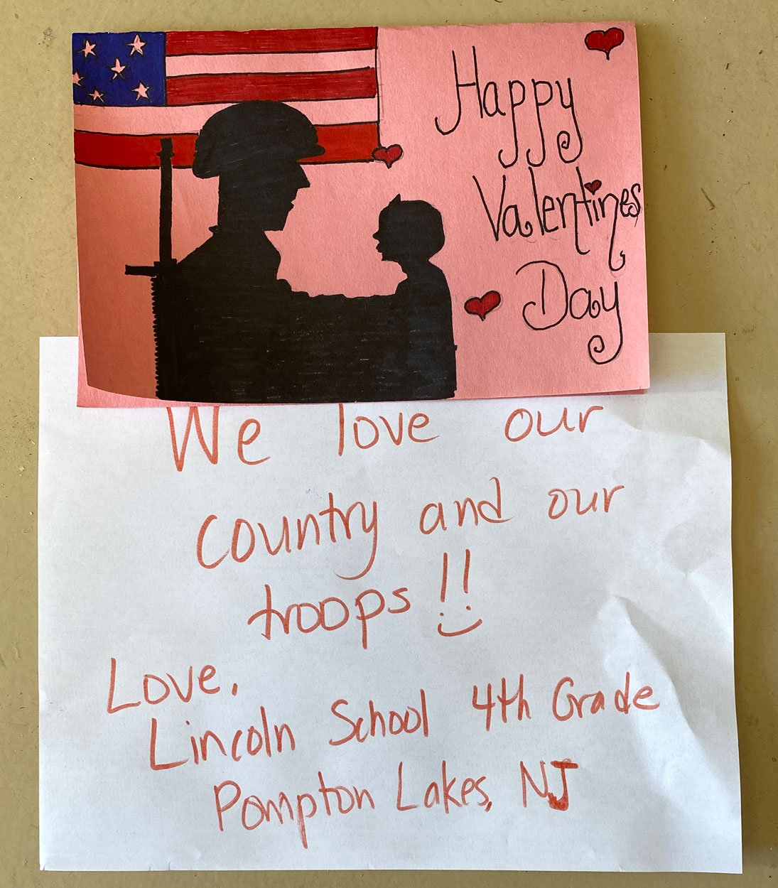 New Jersey, February 7, 2021 –     The 4th Grade students at  Lincoln School, Pompton Lakes, New Jersey say “We love our country and our troops !!:)”  and cleverly converted the SOT soldier&child logo into their Valentine Day card art.   Good job!