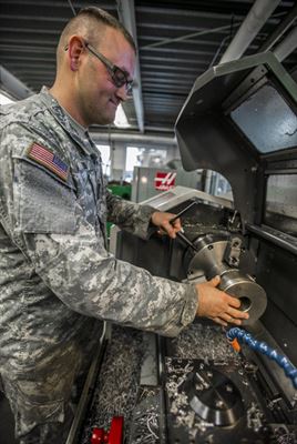 Illinois Army National Guard Sgt. Wesley Todd, of La Porte, Indiana, places his invention that’s used to remove the muzzle break from the light towed howitzer, onto a lathe at the Combined Support Maintenance Shop in North Riverside, Illinois, Sept. 21, 2016. Todd device improves soldiers’ safety and equipment longevity while working on the light towed howitzer. Illinois Army National Guard photo by Staff Sgt. Robert R. Adams